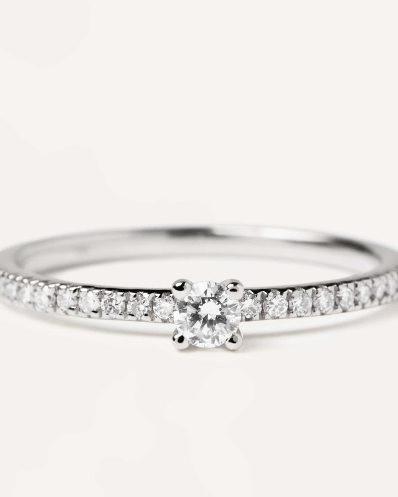 Solid white gold ring with diamond eternity band and a round cut center diamond, making 0.31K