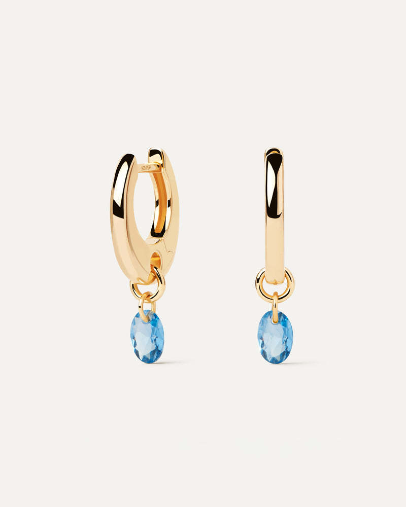 Aros de plata bañada en oro con un colgante de circonita azul en forma de gota