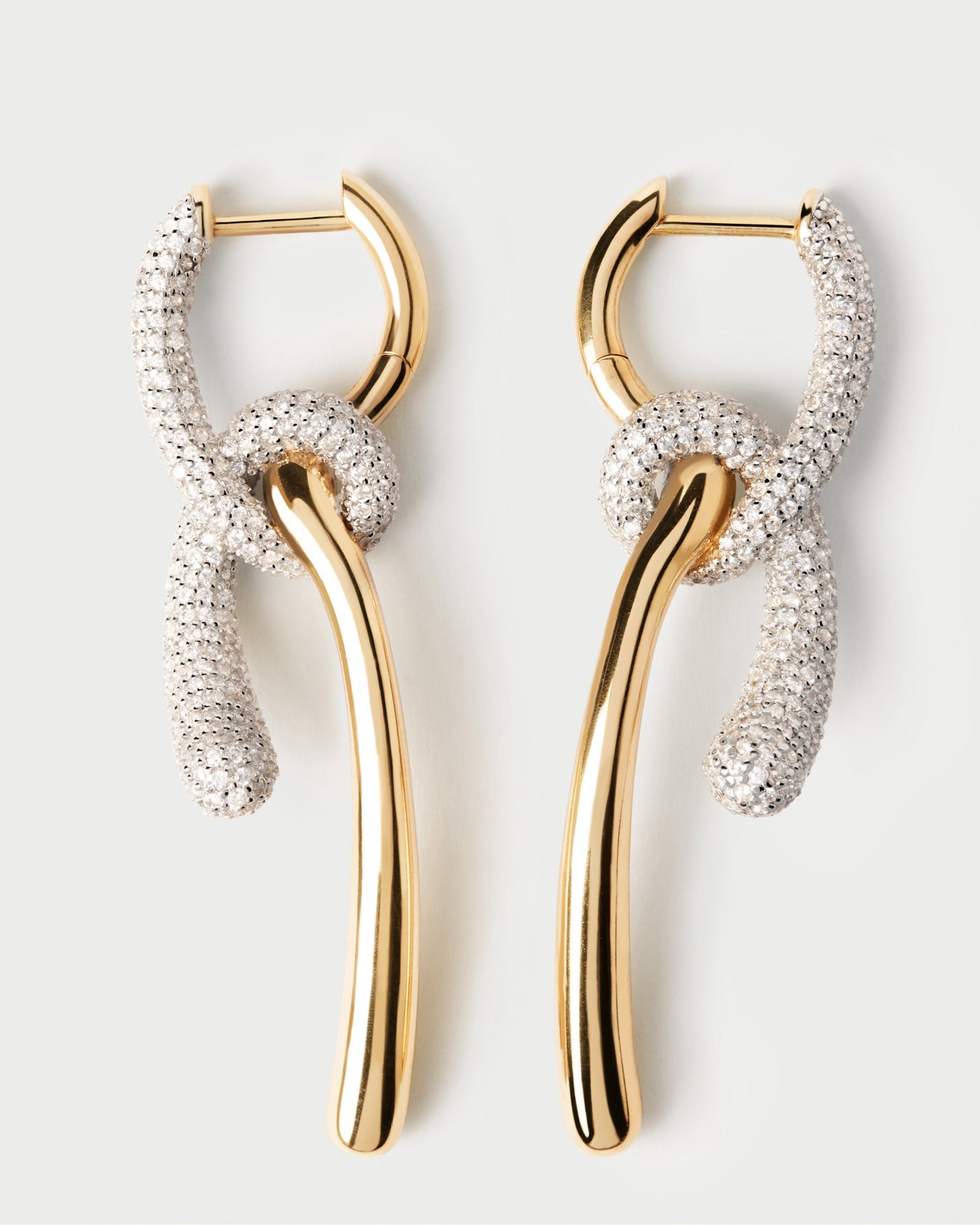 Elegant asymmetrische Creolen mit kontrastierenden geknoteten Pavé-Zirkonia-Anhängern