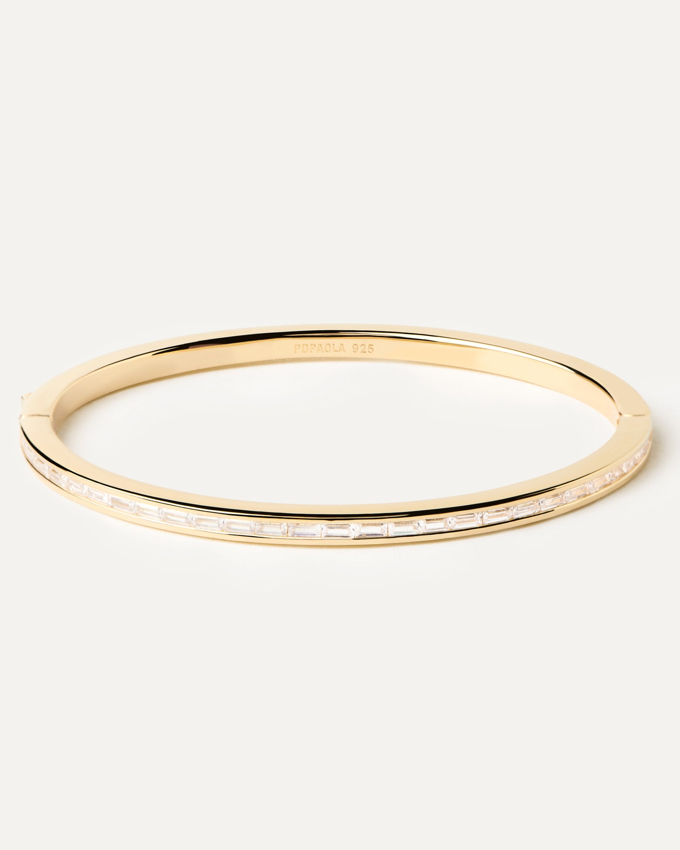 2023 Selection | Viena Bangle. Gold-plated hinged bangle with a band of rectangular cut white zirconia. Get the latest arrival from PDPAOLA. Place your order safely and get this Best Seller. Free Shipping.