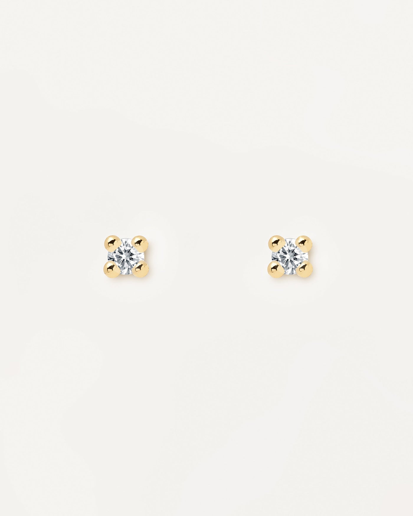 Boucles d'Oreilles Essentia. paire de boucles d'oreilles boutons en argent plaqué or 18k avec une pierre en zircon blanc. Découvrez les dernières nouveautés de chez PDPAOLA. Commandez et recevez votre bijou en toute sérénité.