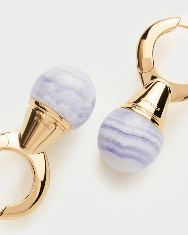 Aros de plata bañada en oro con colgante de piedra azul en forma de esfera