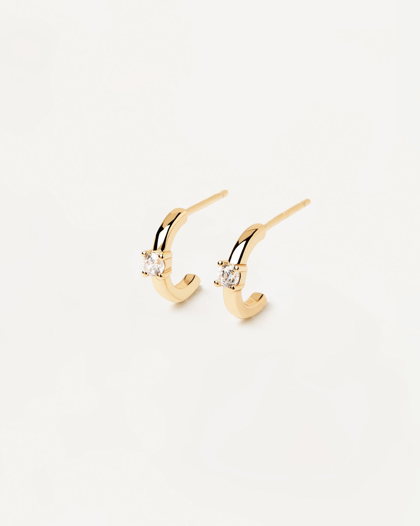 Pendientes White Solitary. aros c en plata bañada en oro de 18k con una piedra de circonita blanca de corte redondo engarzada. Consigue las últimas novedades de PDPAOLA. Haz tu pedido de forma segura y obtén este Best Seller.