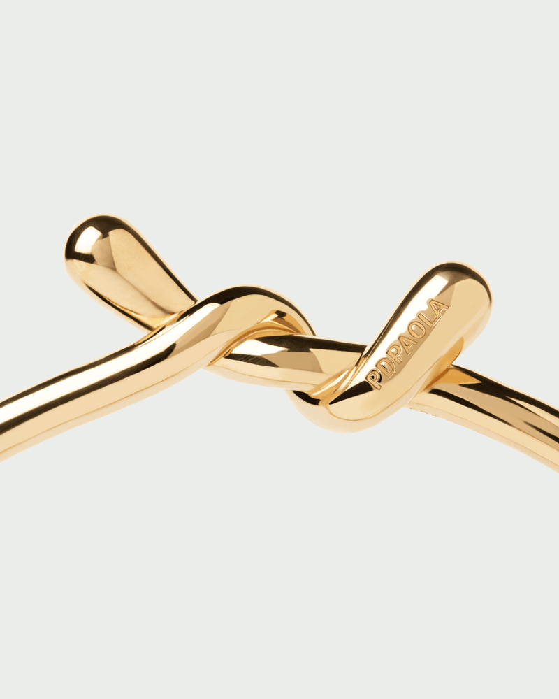 Bracciale rigido distintivo in argento placcato oro con designo fluido e intrecciato