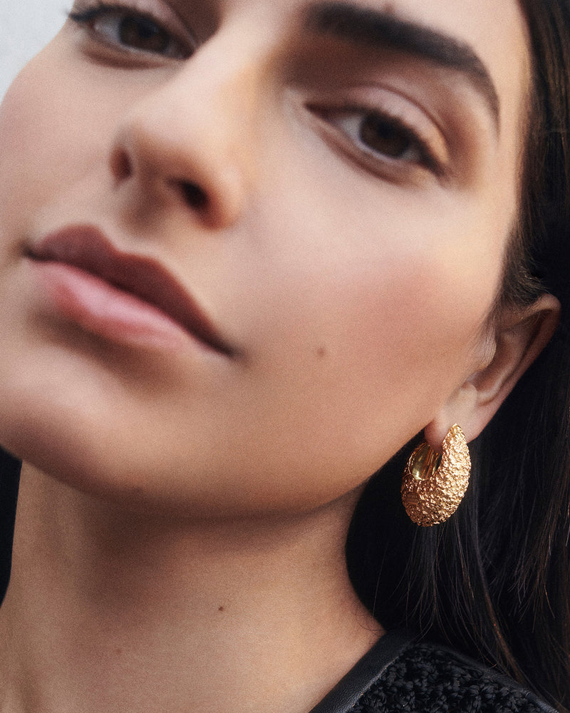 Chunky hoop earrings with molten texture and embossed logo on the front